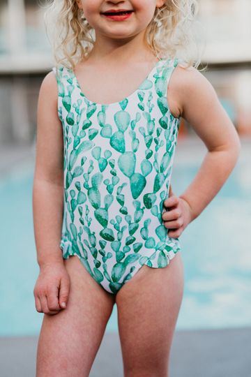 PINK DESERT GIRLS MINI RUFFLE LEG SCOOP ONE PIECE SWIMSUIT IN CACTUS